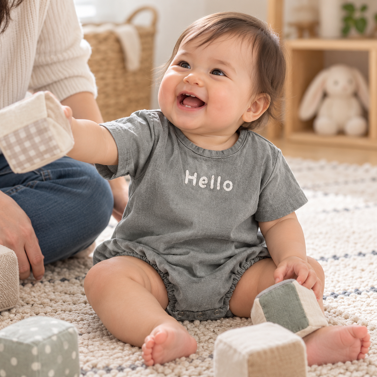 Baby laughing and playing in pink Hello bubble romper