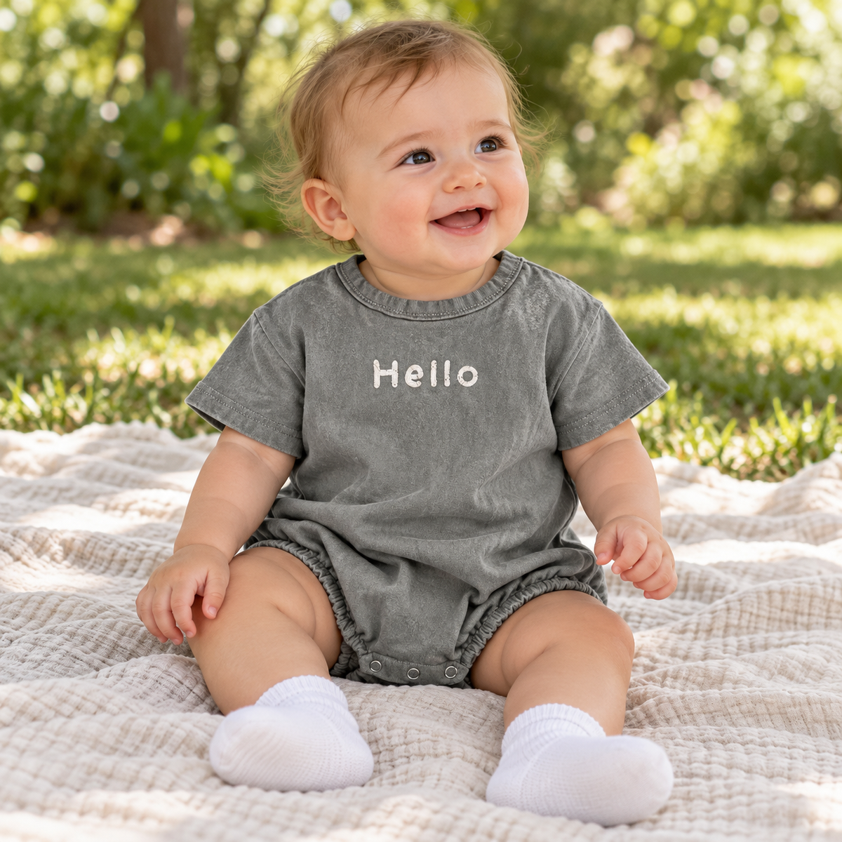 Baby styling the gray Hello romper outside in spring