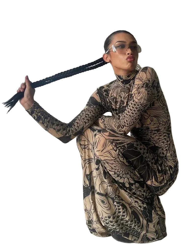 Person wearing a long, patterned dress with a large black braid, standing in an urban setting.
