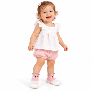 Toddler on white background wearing Pink animal knit sock shoes