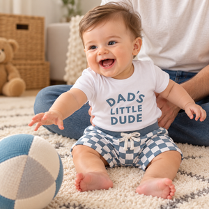 Baby laughing in DAD'S top and checked shorts