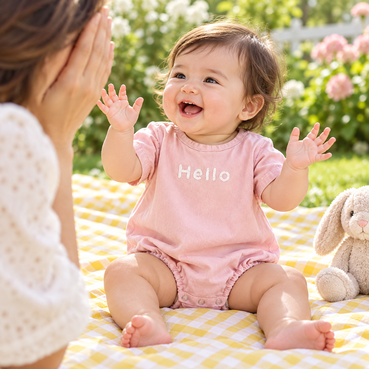 Baby happily playing in gray Hello bubble romper