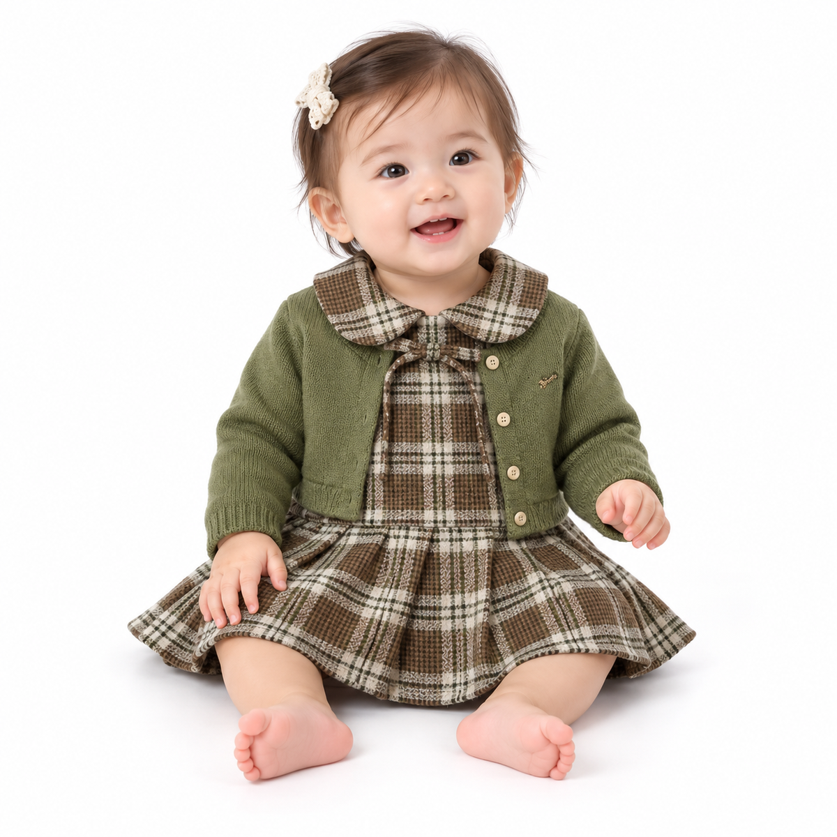 Baby modelling the plaid dress and matcha green cardigan set on pure white